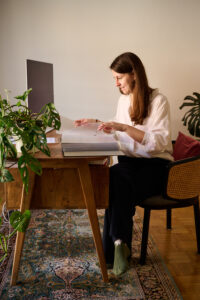 Sandra Block bei der Supervision am Schreibtisch mit einer großen Mappe voller Übungen